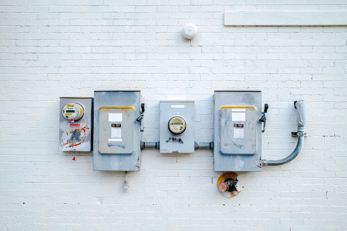 Electric meters and disconnect boxes mounted on a white brick wall in Chattanooga, Tennessee