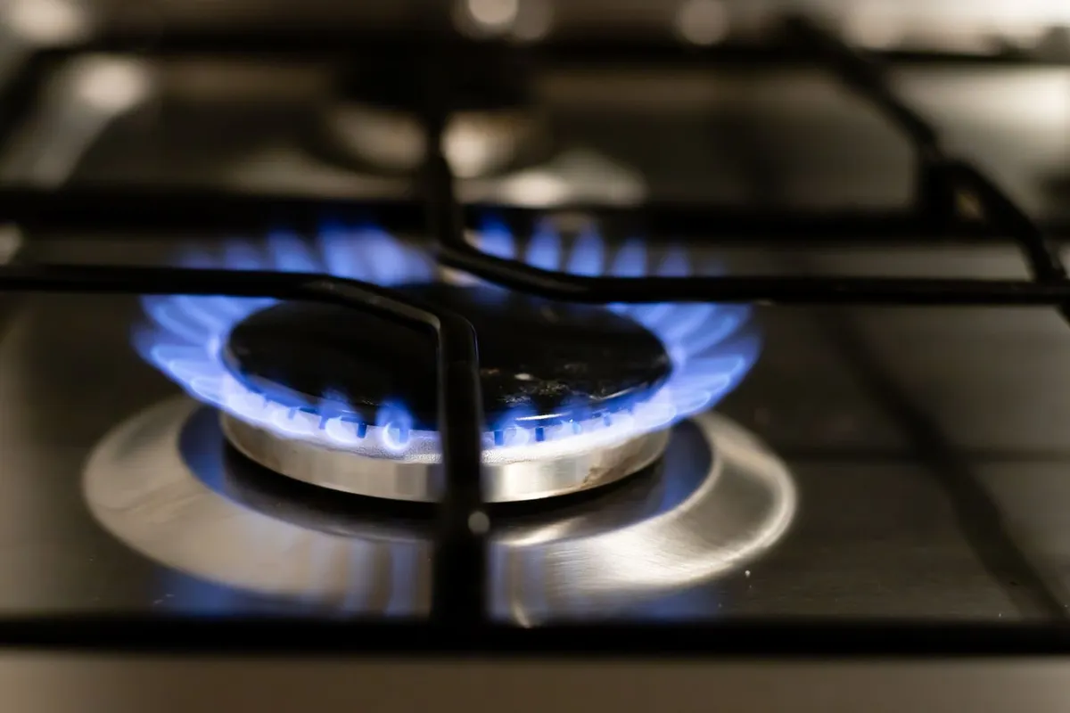 Blue flames on a gas stove burner in a kitchen