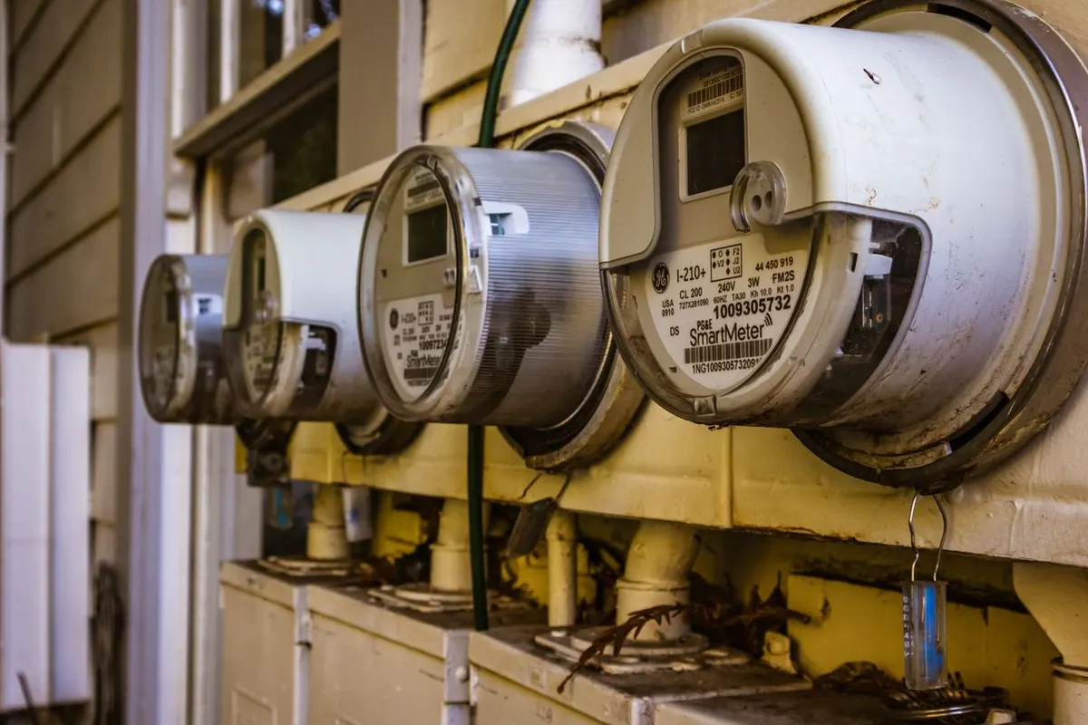 Row of residential smart electric meters on the outside wall of a U.S. home